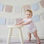 <font dir="auto" style="vertical-align: inherit;"><font dir="auto" style="vertical-align: inherit;">Prendre soin de soi pour prendre soin des autres</font></font> Cute baby standing by a stool indoors with a playful background.